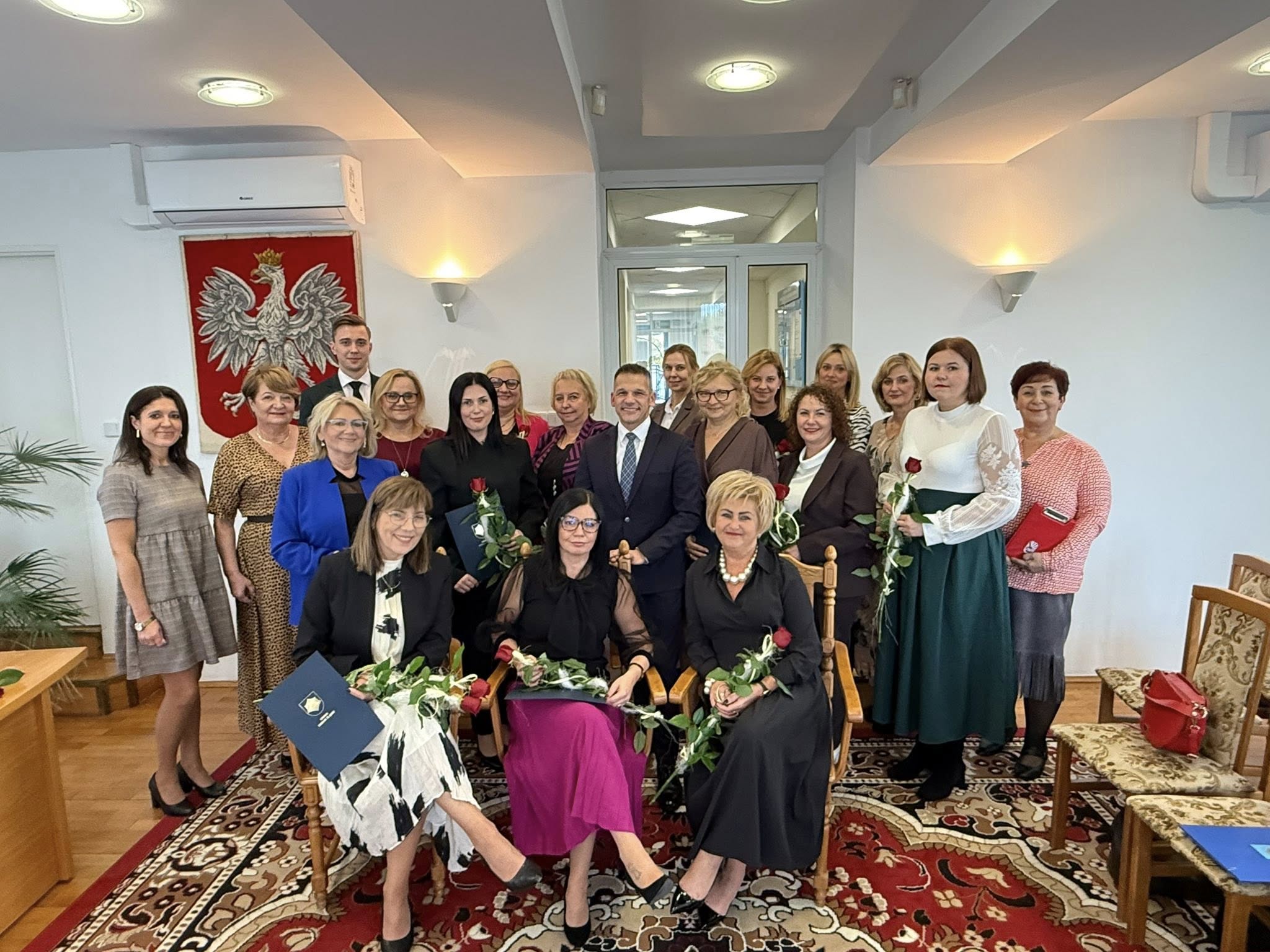 Grupa osób pozujących do zdjęcia w pomieszczeniu