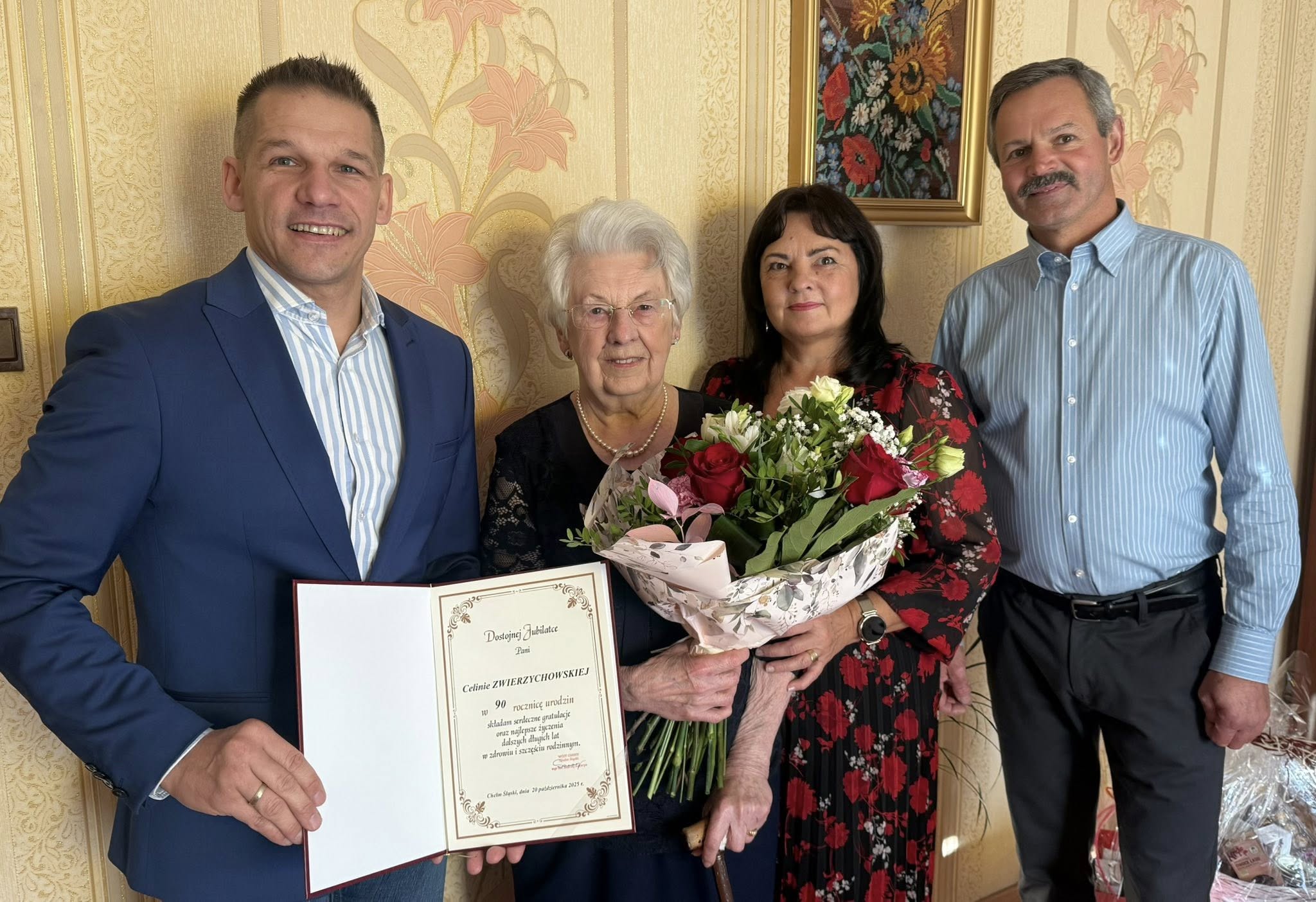 Cztery osoby pozujące z kwiatami i dyplomem do zdjęcia