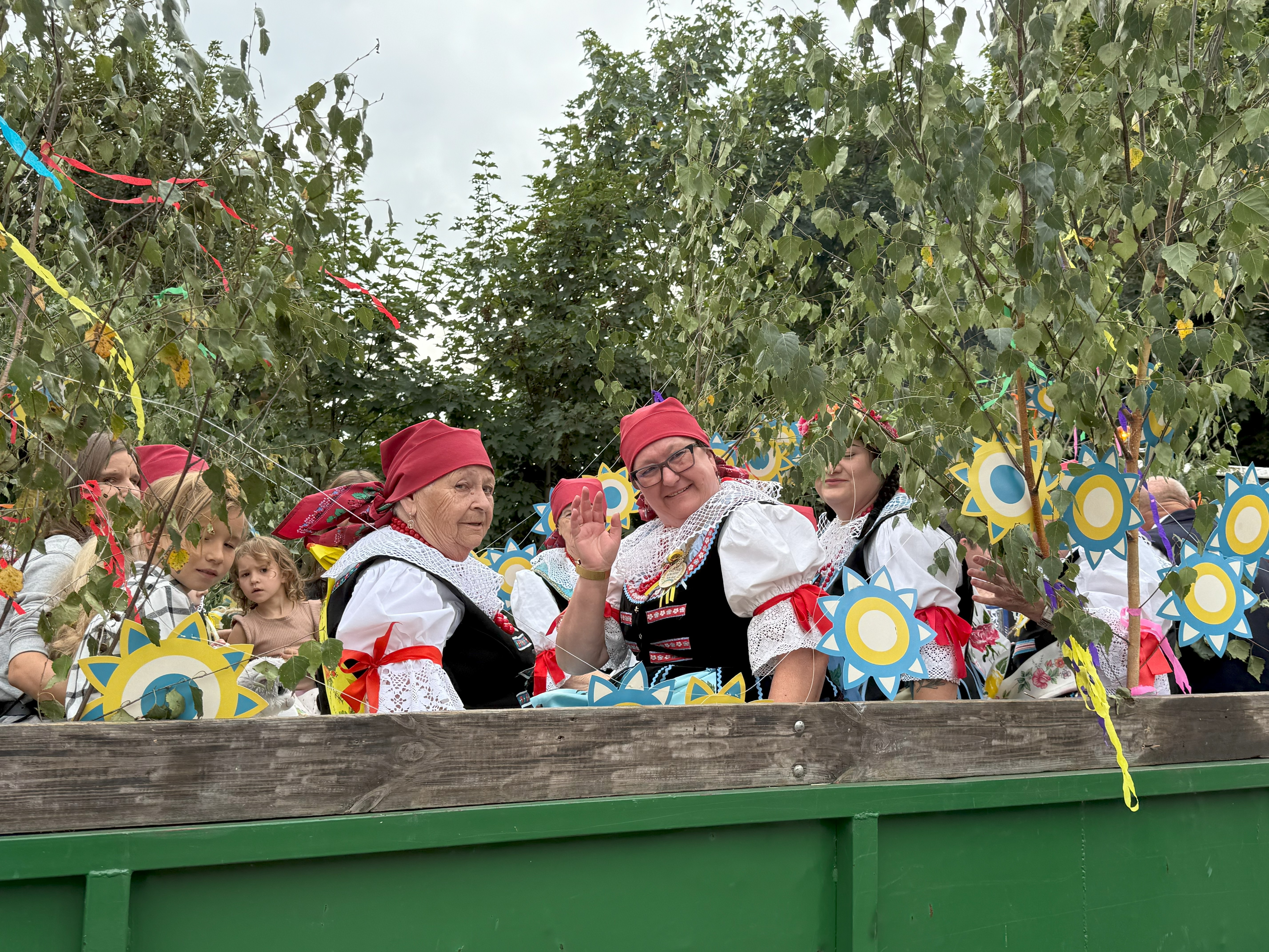 Kobiety siedzące na wozie w strojach ludowych